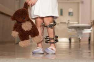 ребенок в больничной одежде с игрушкой в руках проходит курс лечения от артрита