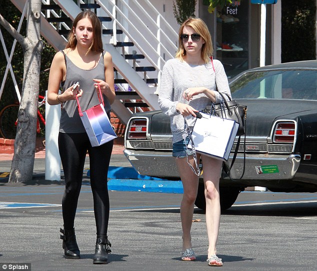 Black and blue: Emma Roberts, right, was sporting a huge bruise on her leg as she ran errands and hung out with a friend in Hollywood, California, yesterday afternoon