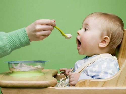 Ребенка кормят из ложки